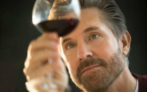 Sommelier profesional realizando la fase olfativa de una cata de vino tinto para análisis sensorial.